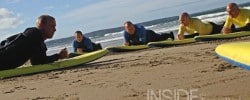 Lying on the sand during a surf lesson