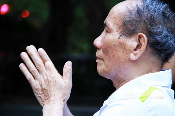 A man prays at Hoan Kiem lake in Hanoi - travel tips for Vietnam