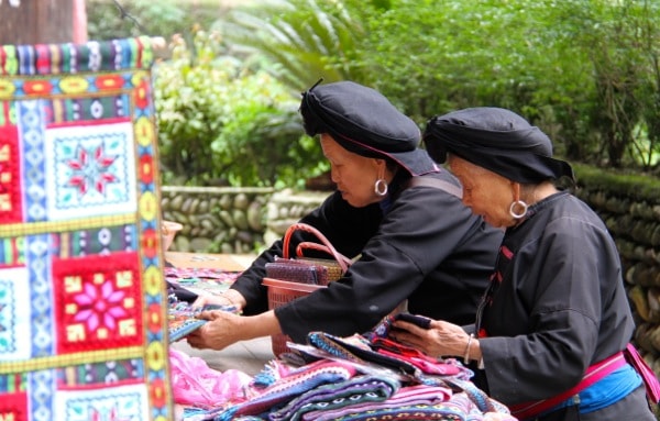 Women preparing handmade textiles in Longji outside the Yao women rice water show