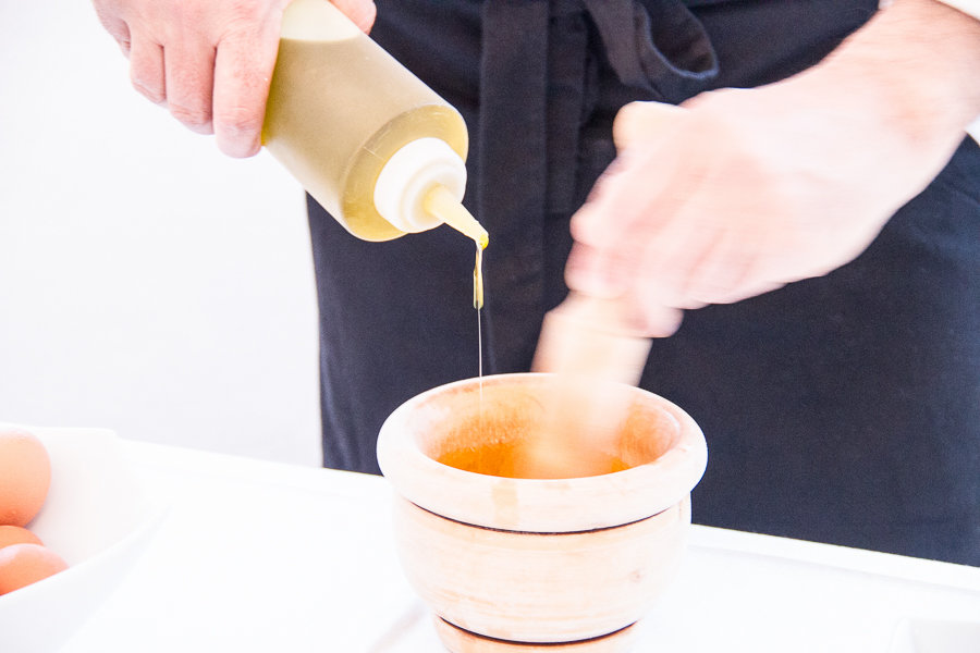 Making real mayonnaise in Menorca by dripping oil into a pestle and mortar