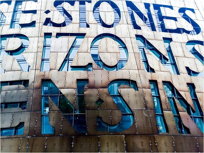 The shimmer of metal and stone at the exterior of the Armadillo opera house in Cardiff Bay - the words say In these stones, horizons sing