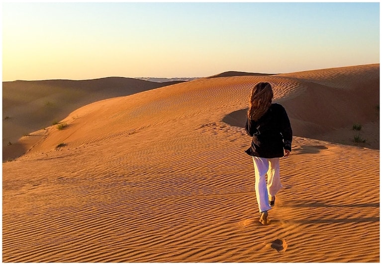 Abi from Inside the Travel Lab striding into the desert