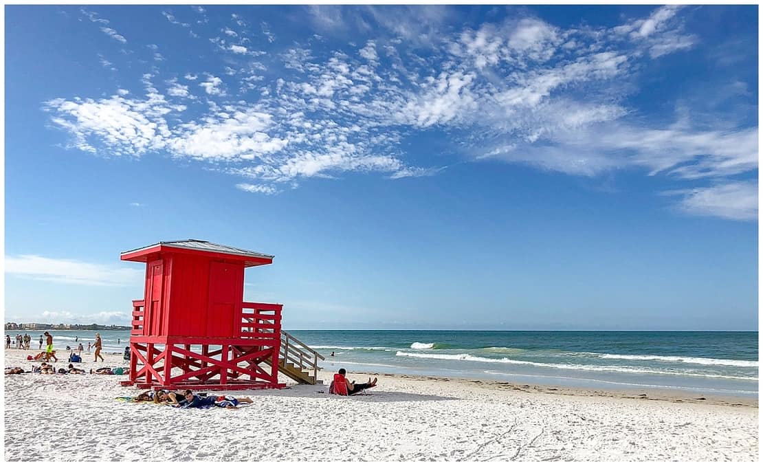 White quartz sand, clear turquoise water and a red lifeguard stand at Siesta Beach, Florida