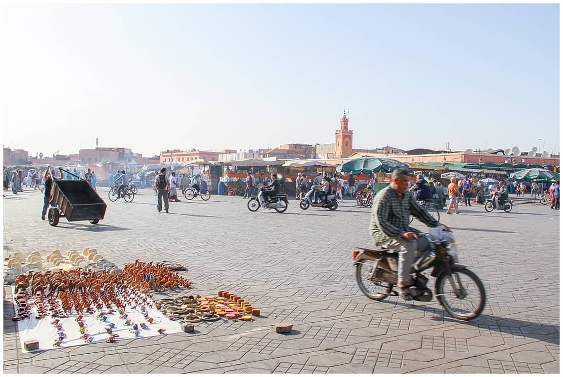 Man riding a motorbike through the Jemaa el-Fnaa in Marrakech, Morocco - Marrakech in winter