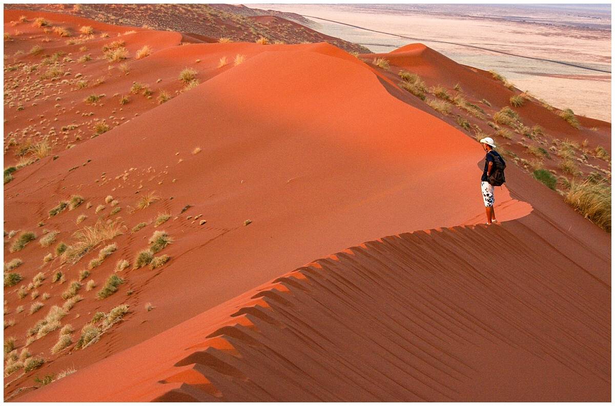 Standing on blood red sand dunes in Namibia