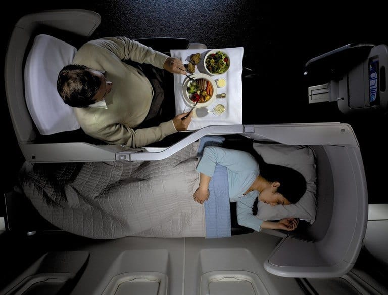Overhead view of Club World British Airways Businsess Class with one passenger eating one sleeping