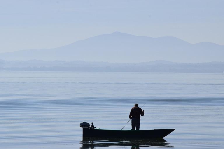 Lake Trasimeno in Umbria Italy person standing in boat with silhouette behind