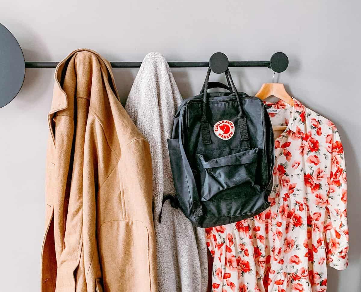 Minimalist wardrobe when packing to travel - clothes hanging on wall