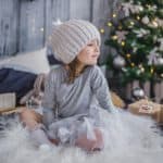 Gift Ideas for Kids - girl on rug in front of Christmas tree