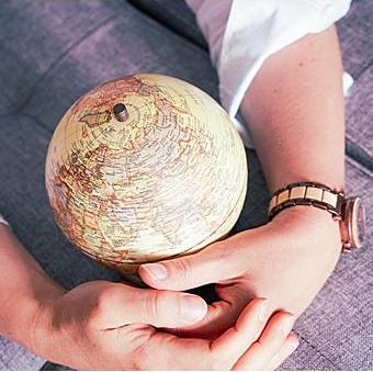 Hands around globe destination planner