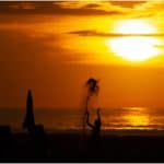 Sunset captions and sunset quotes-Sabah sunset with boy throwing sand