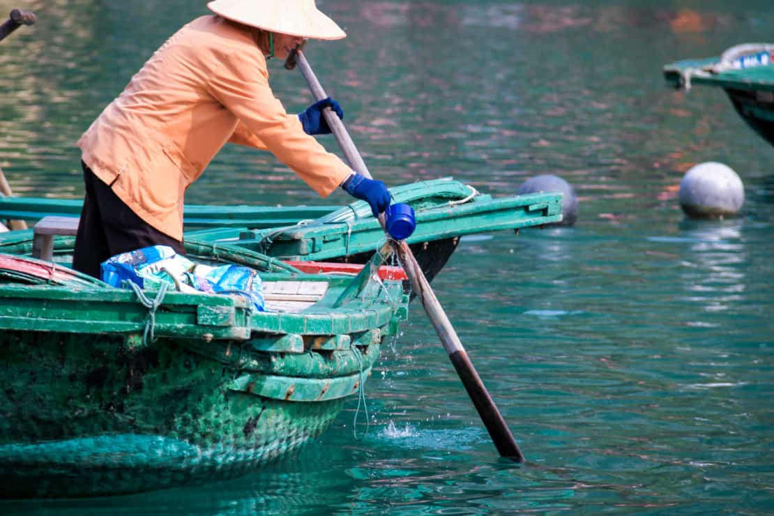 Vietnam - Halong Bay - Vung Vieng Floating Fishing Village Woman Rowing boat to gather tourists