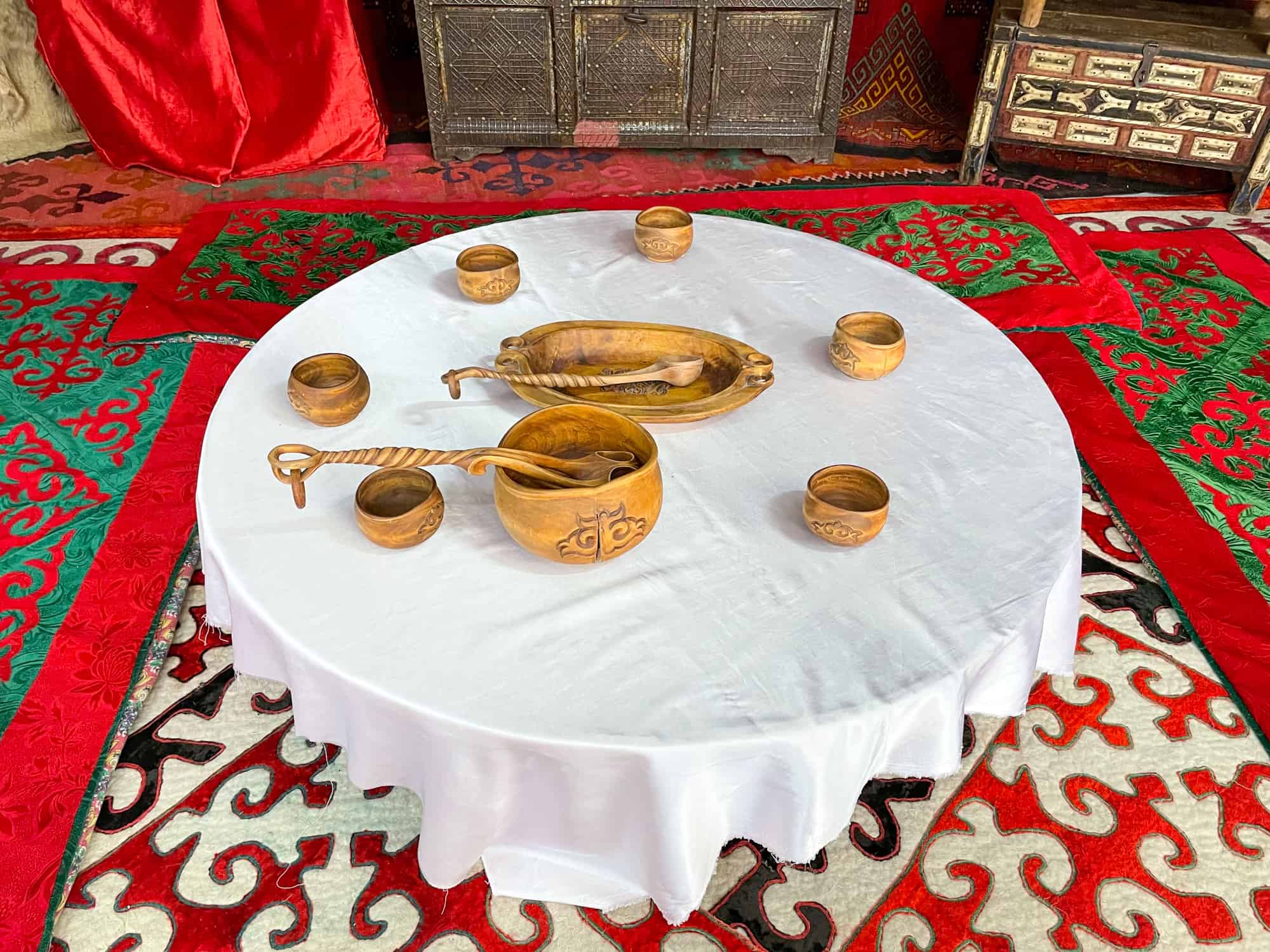 Kazakhstan Food - traditional wooden pots and serving platters on a low table