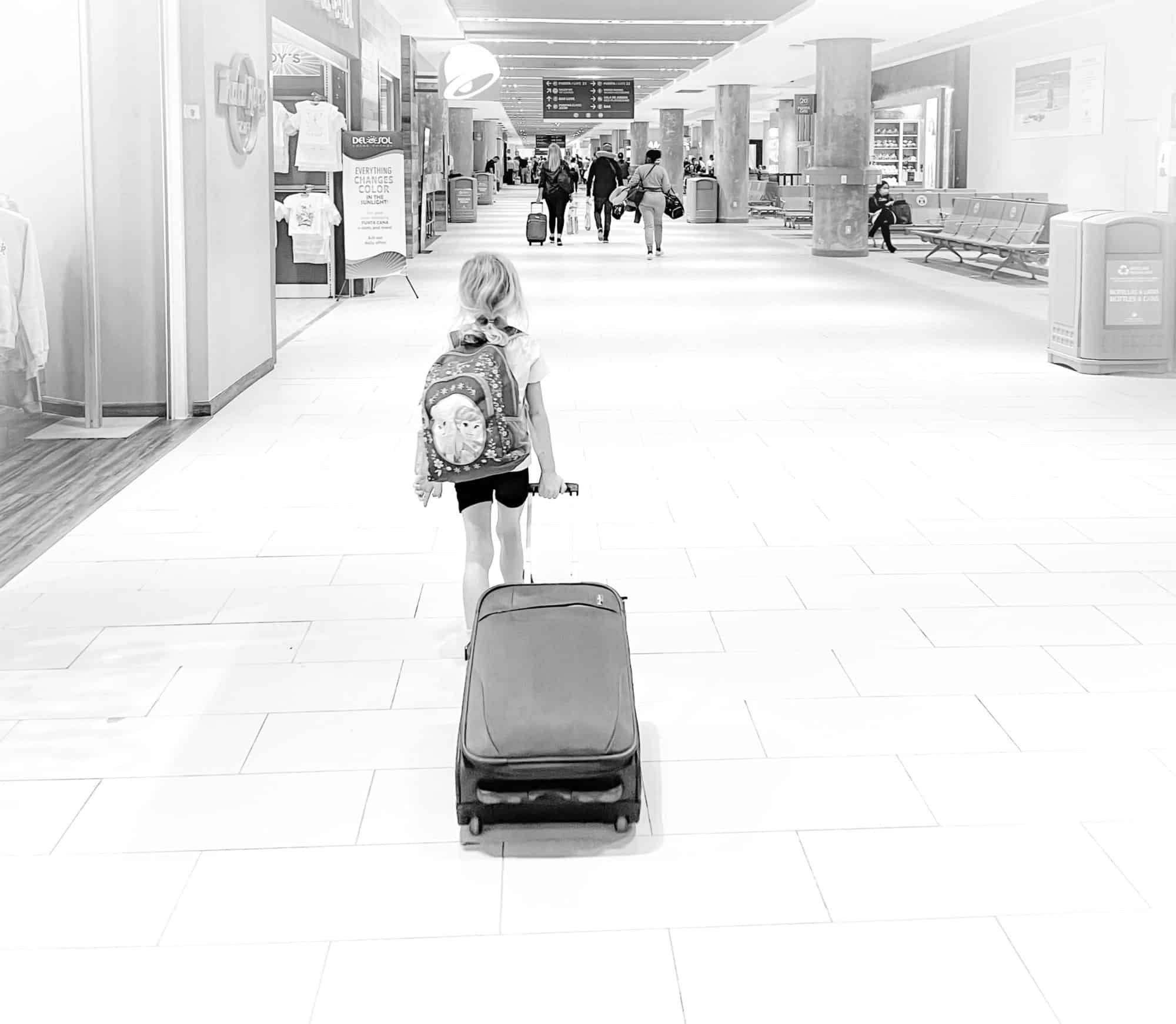 Travel to the Dominican Republic with kids - child with suitcase in airport at Punta Cana