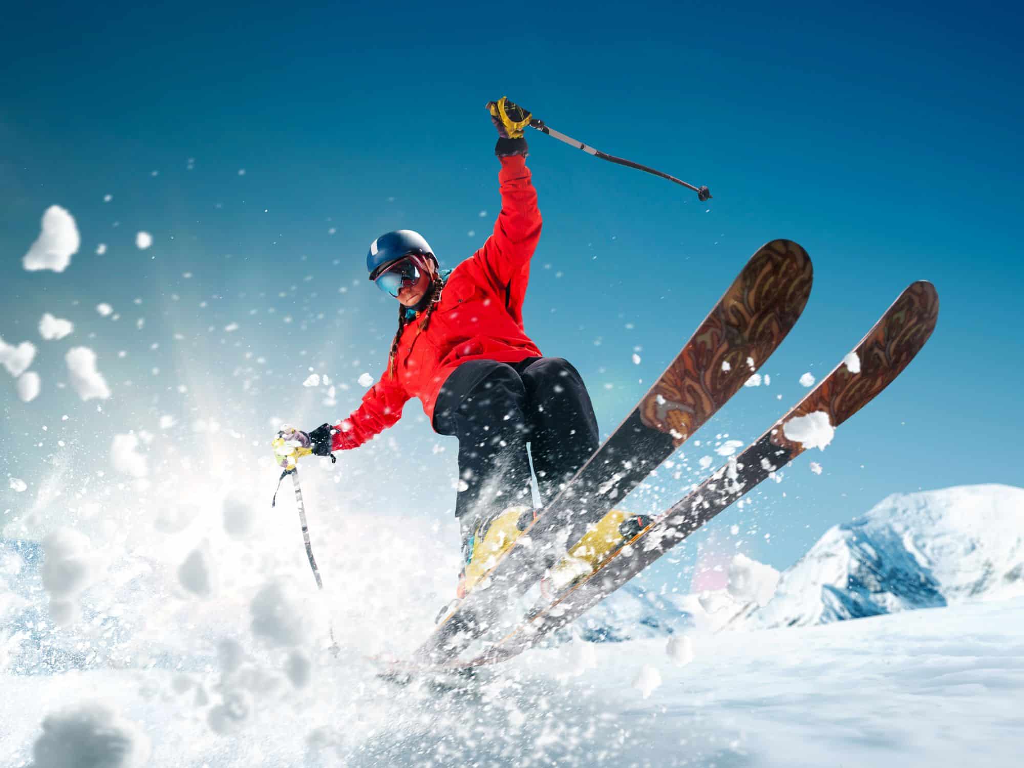 What to pack for a ski trip - ski through powder in a red top