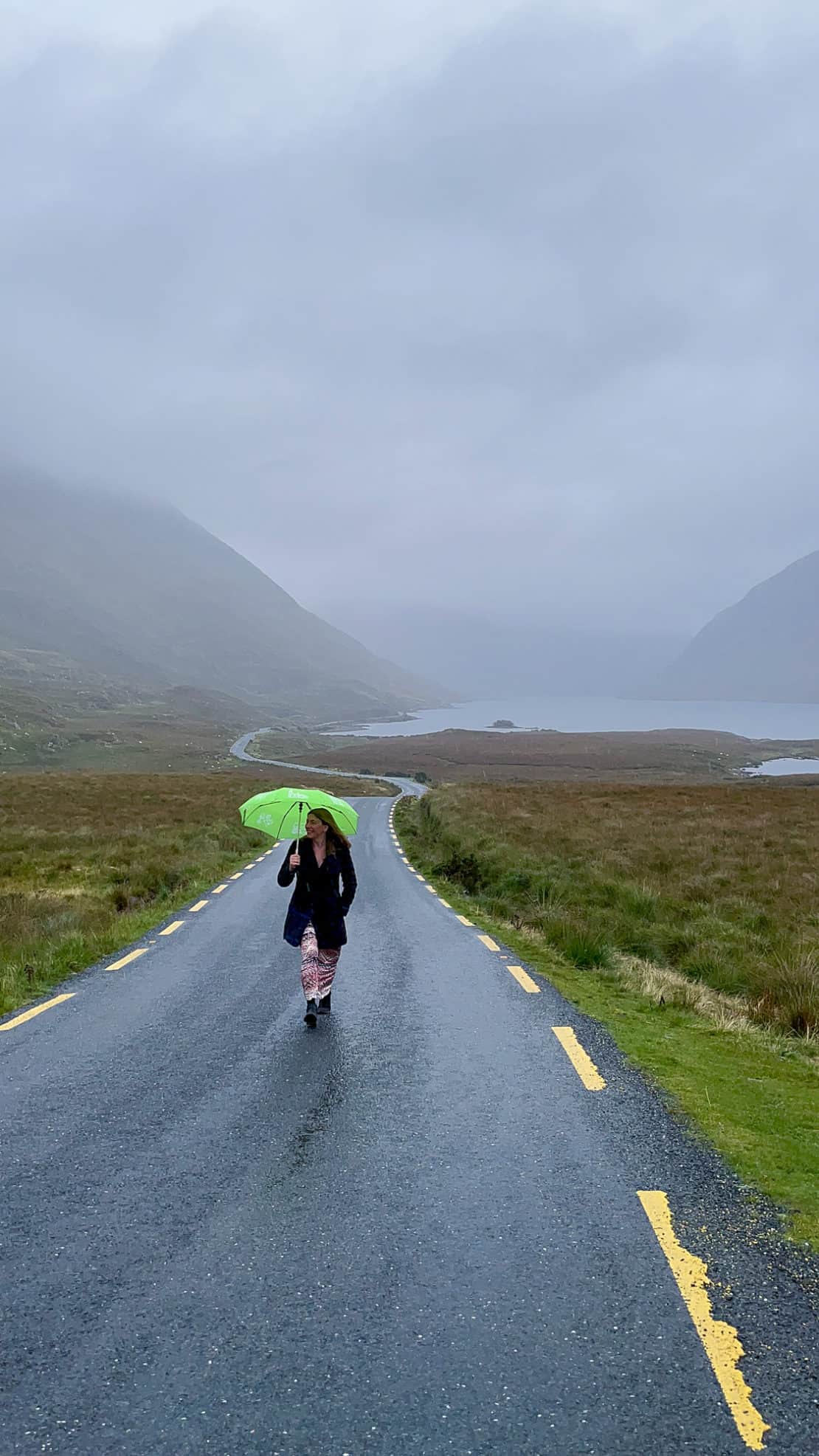 Ireland - rural road with mist - Abigail King with umbrella