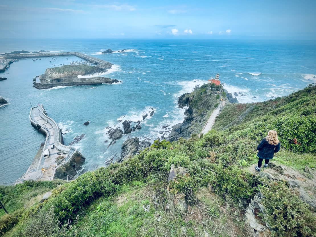 Spain - Asturias - Abigail King standing on the Cudillero viewpoint looking out to sea