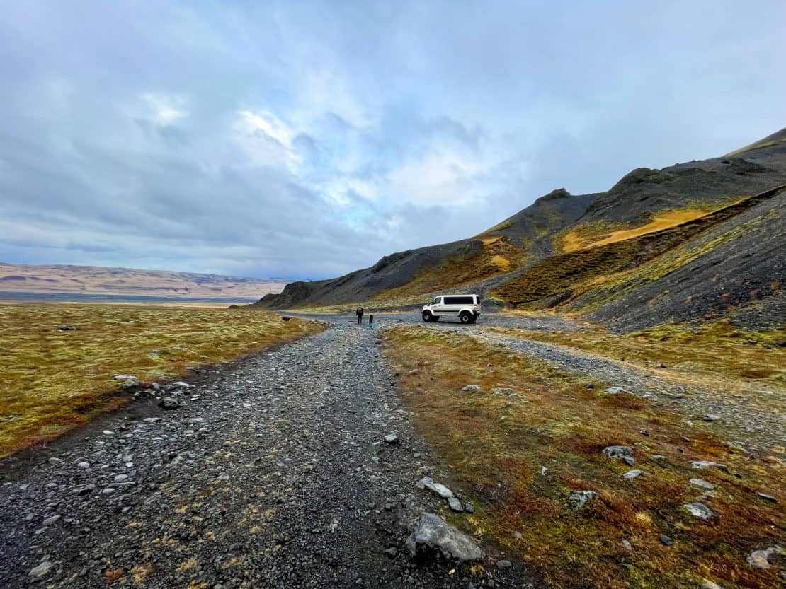 Father and daughter walk towards a super jeep in Iceland