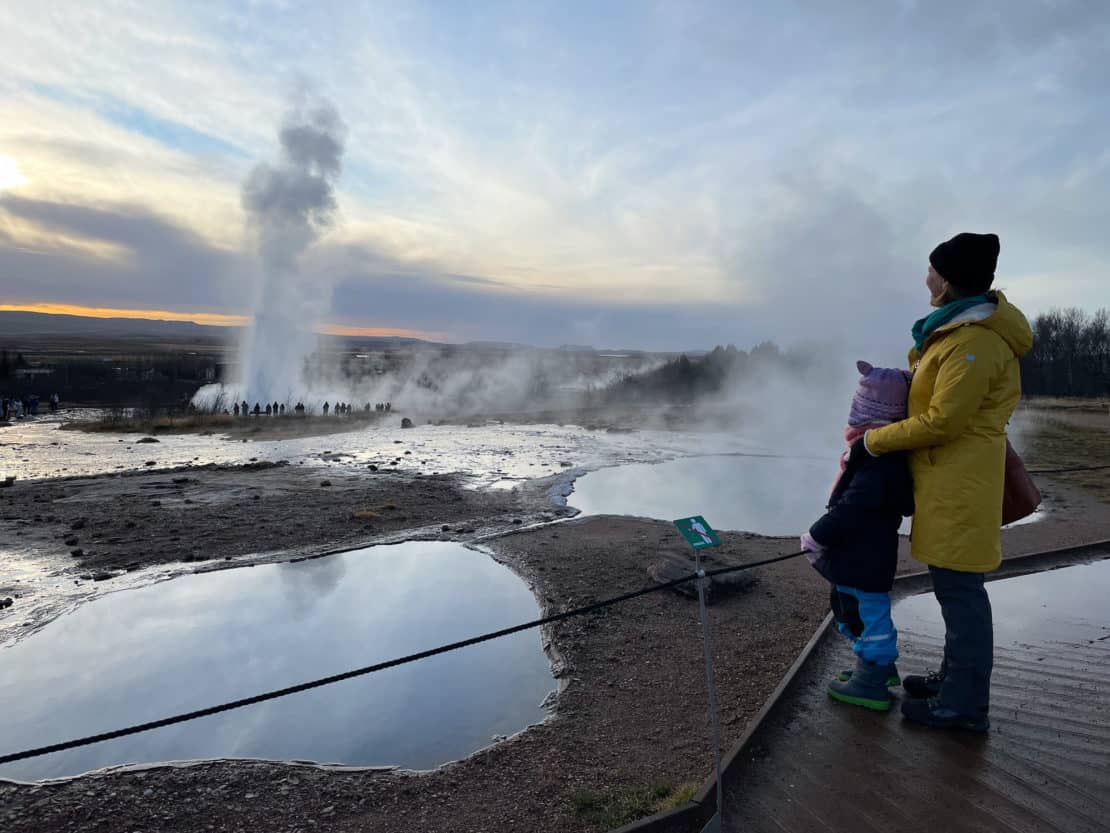 Mother and daughter looking at geysers erupting in the Golden Circle in Iceland.