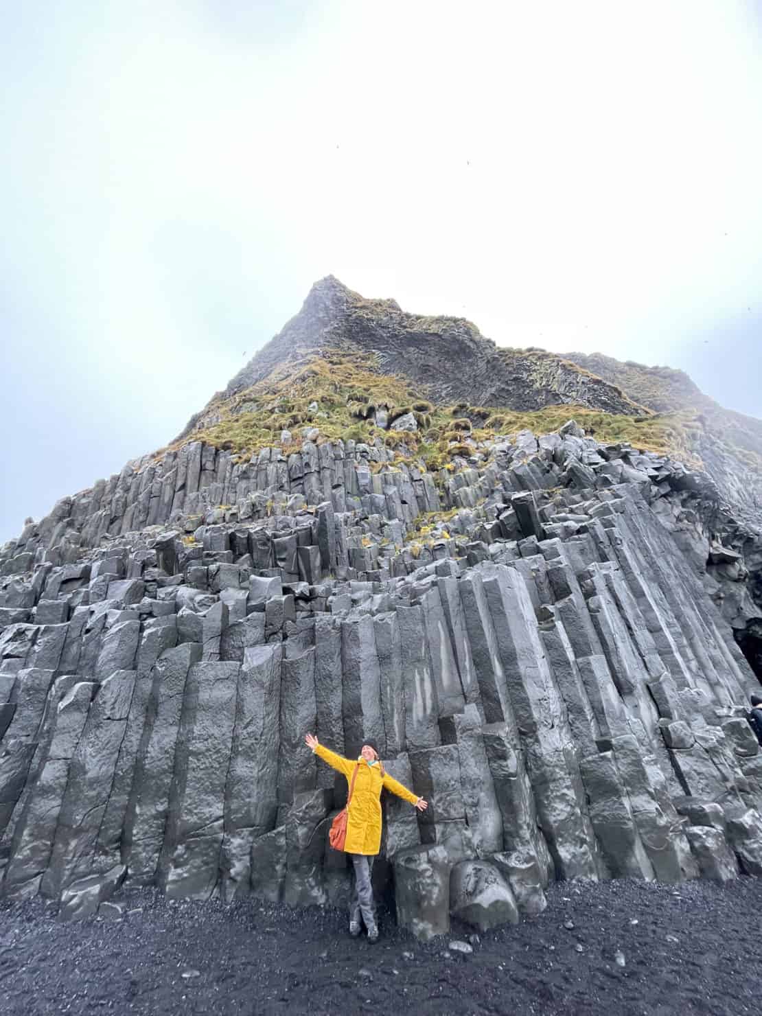 Iceland - Reynisfjara beach - Abigail King against stone black columns