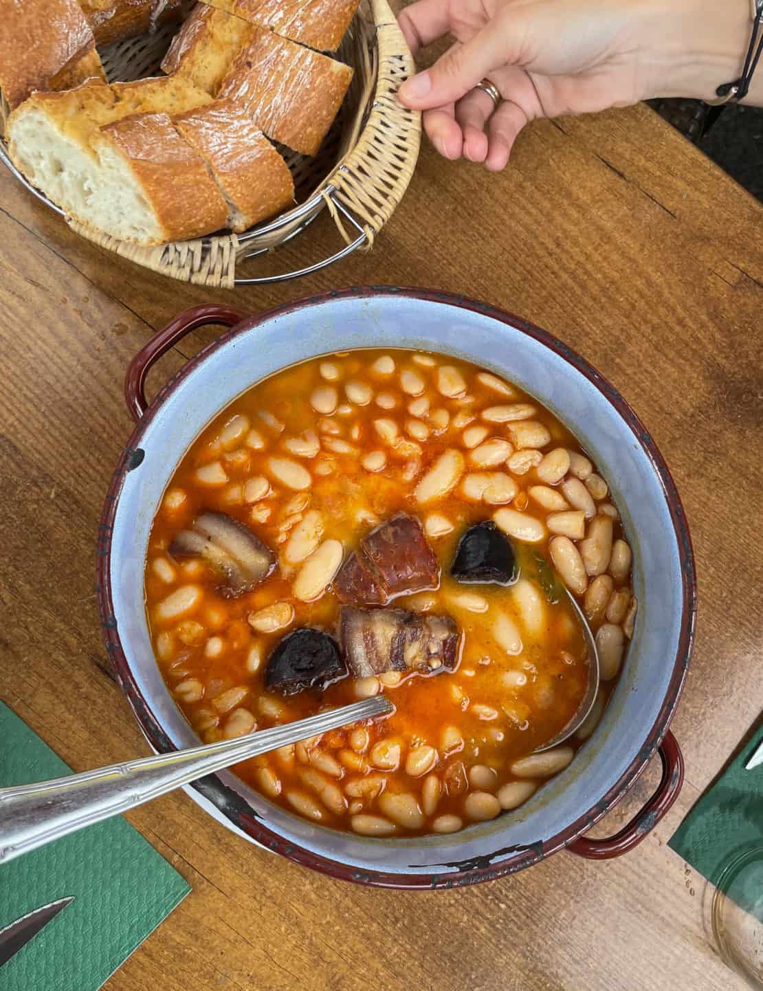 Spain - Asturias - bowl of fabada stew with big ladle ready to serve
