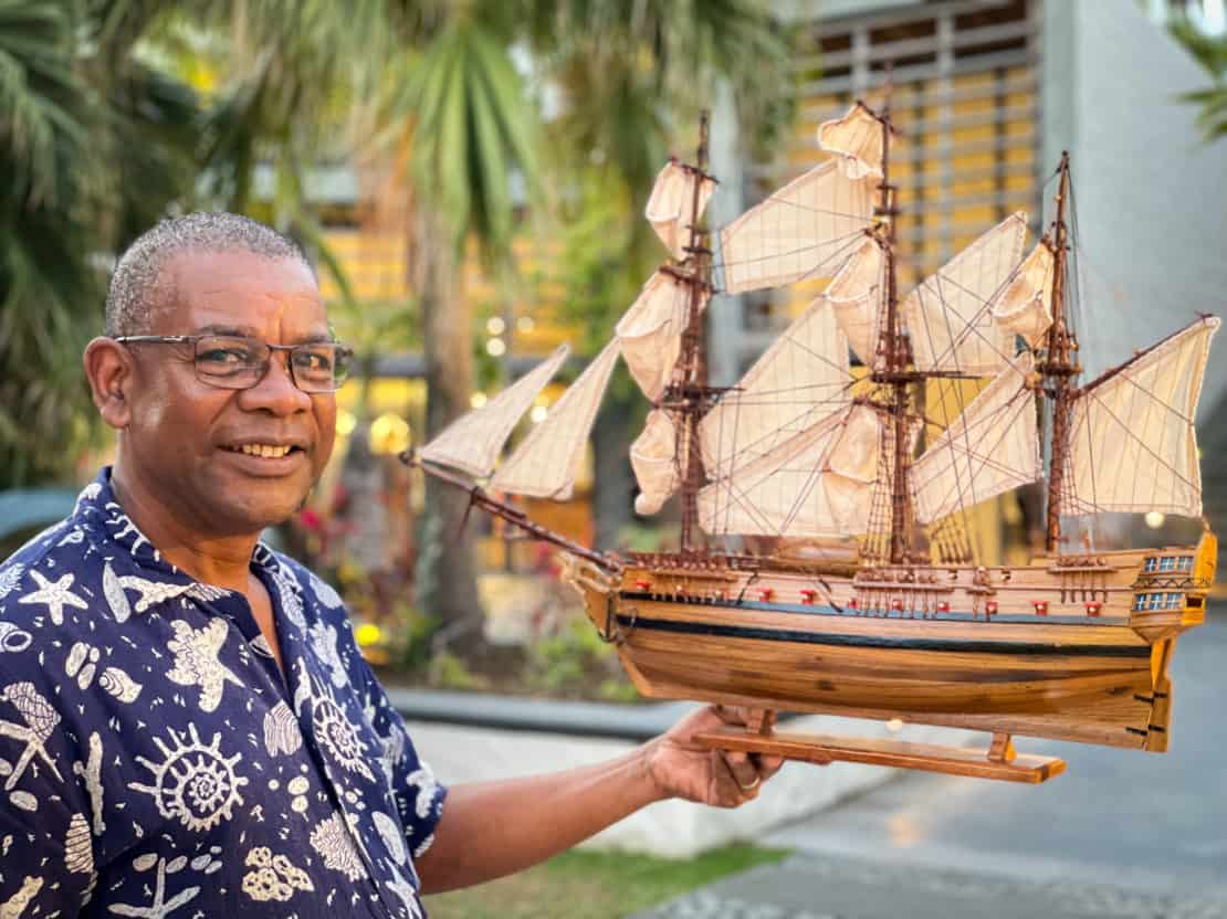Man holds his miniature wooden ship as an example of the traditions and cultures of Mauritius in the Piazza at the Sunlife Long Beach Hotel