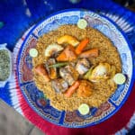 Traditional Gambian dish of benachine served on a blue dish with a side of vegetables