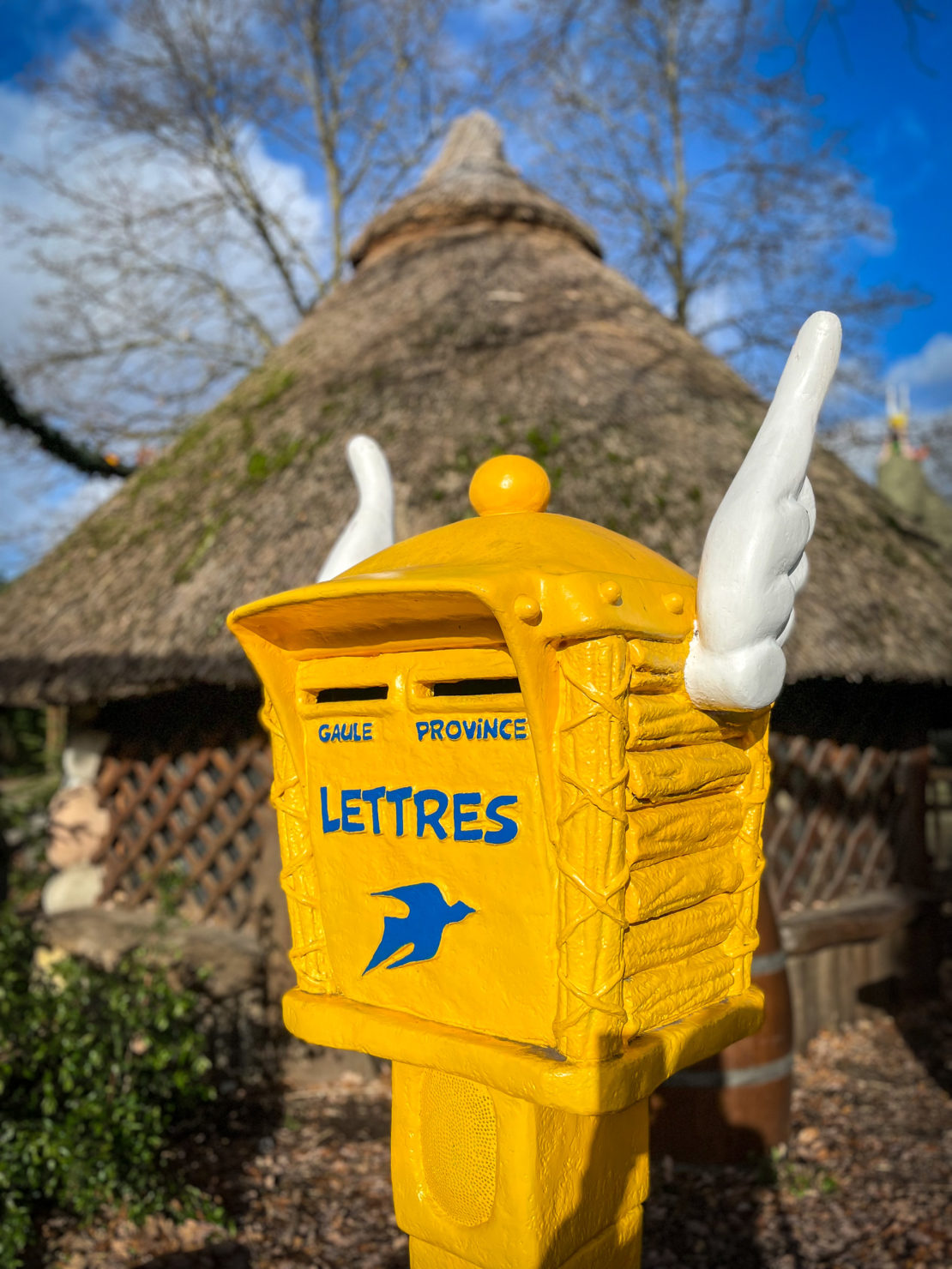 Yellow traditional French postbox with Asterix wings at the Gallic village in Parc Asterix