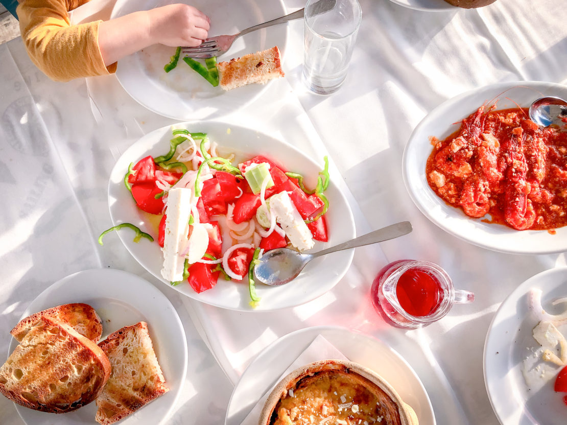 Traditional Greek food in a platter including prawns and Greek salad