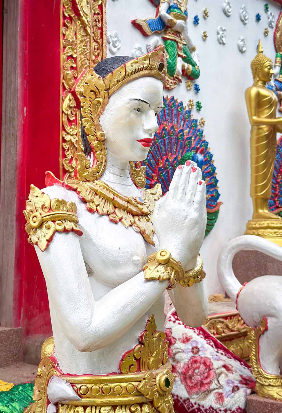 Temple sculpture in Nan Thailand of a woman praying