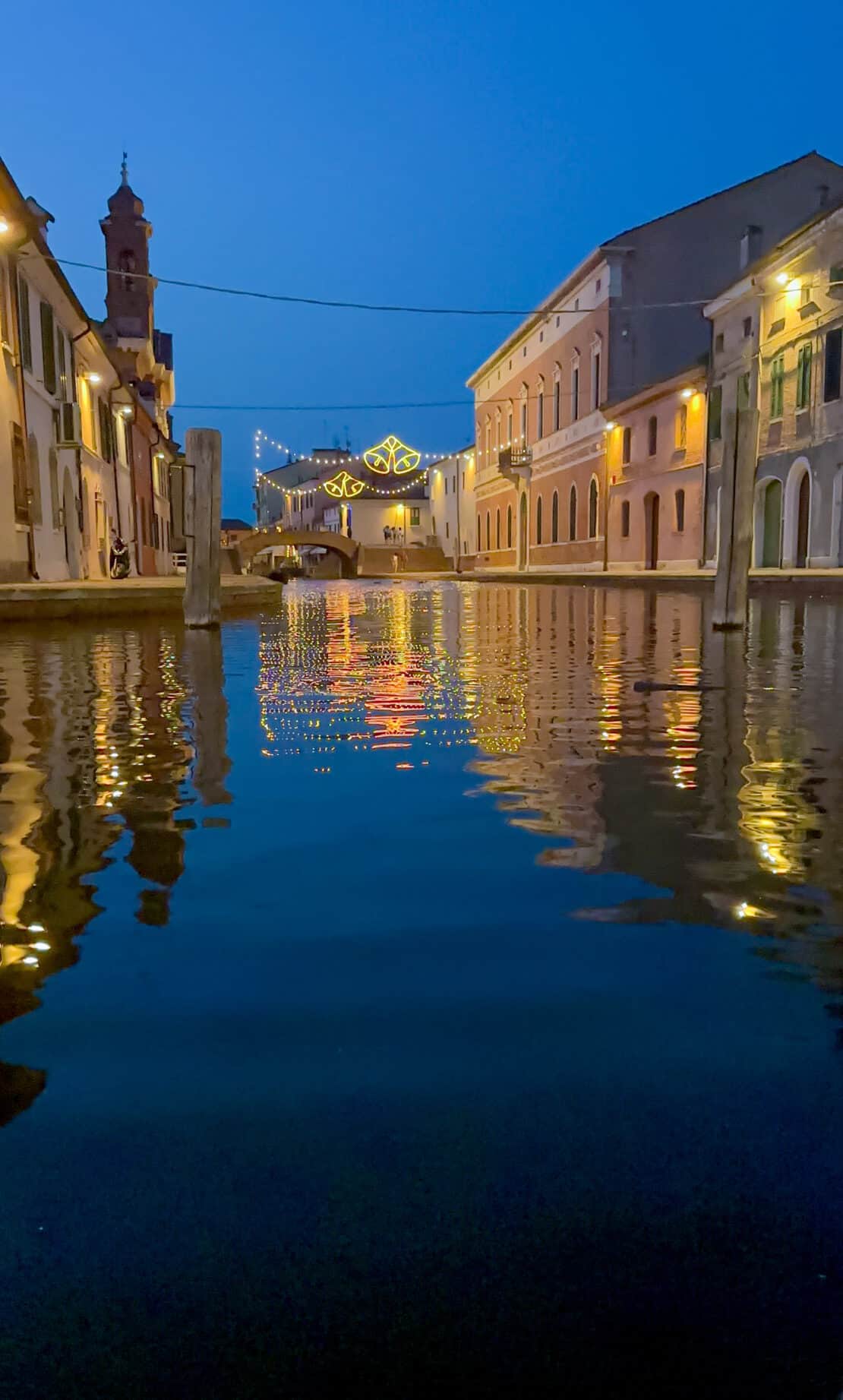 Twilight in Comacchio Italy with buildings reflected in water