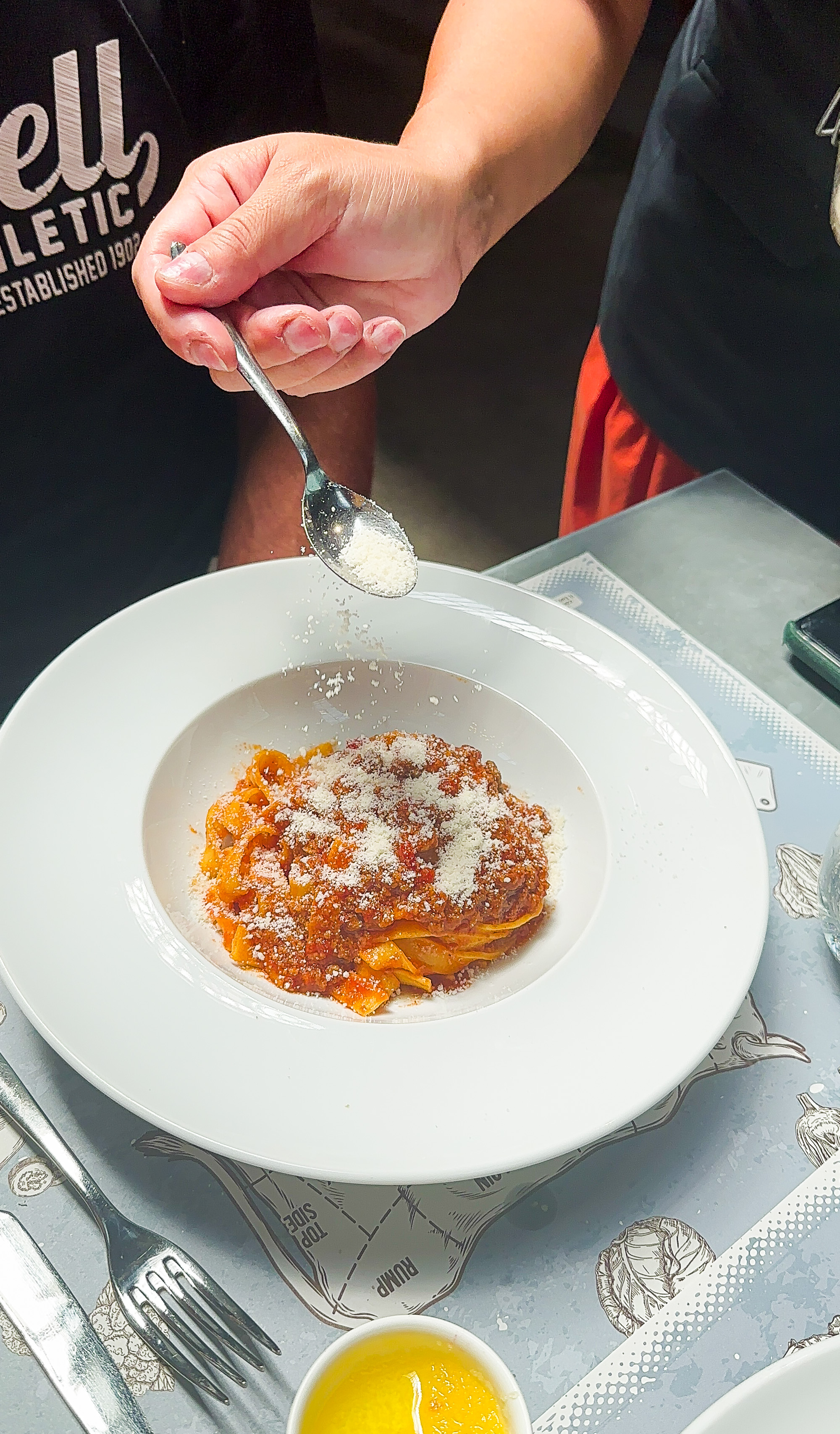 Italy-Ravenna-Mercato-Coperto-Restaurant-serving-parmesan-over-tagliatelle-and-ragu
