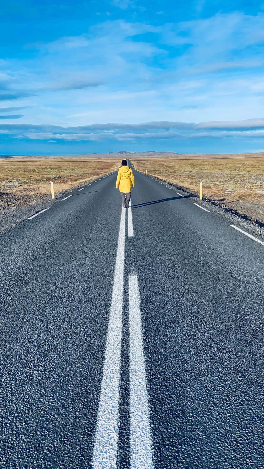 Abigail King walks along an empty road in Iceland