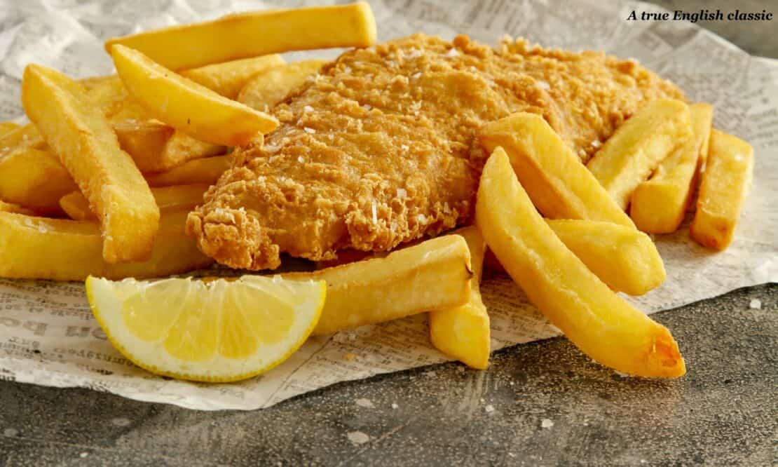 Fish and chips served on newspaper with a lemon 