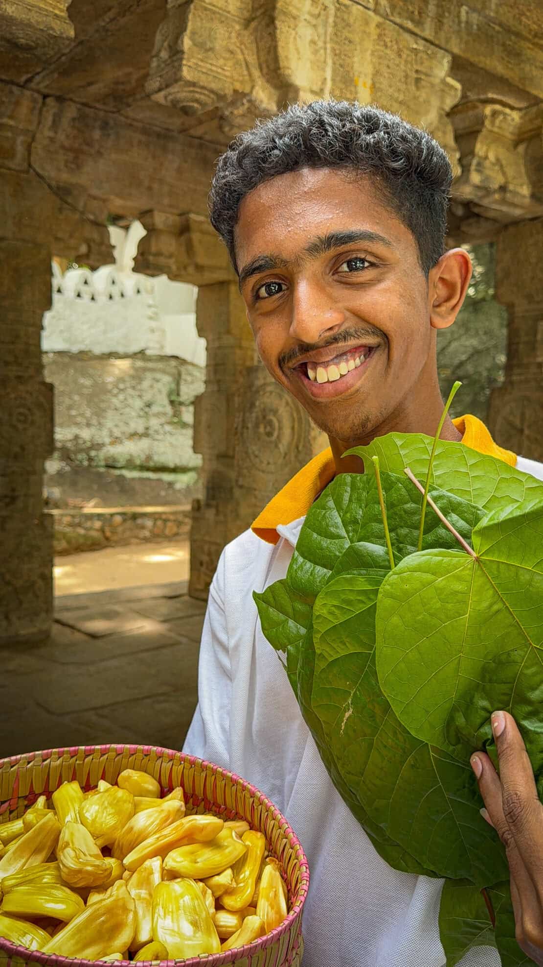 Man holds offerings at the Silver Temple in Sri Lanka - Ridi Viharaya