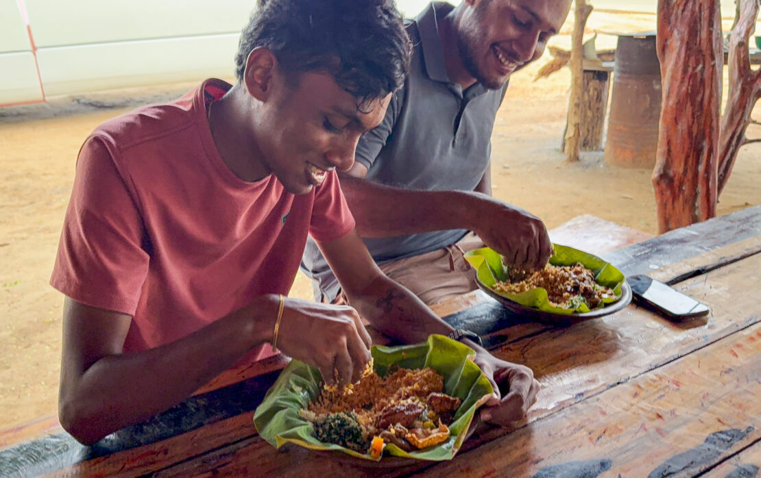 Two men eat a traditional Sri Lankan meal with their hands in Jaffna - things to do in Jaffna