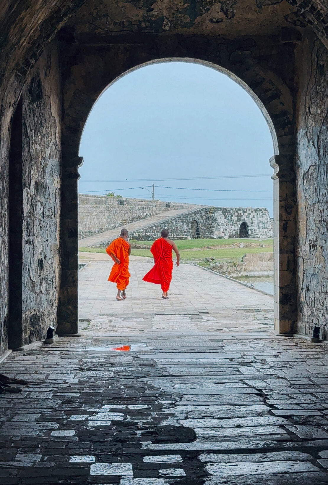 Two monks walk through an arch at Jaffna Fort, Sri Lanka - things to do in Jaffna