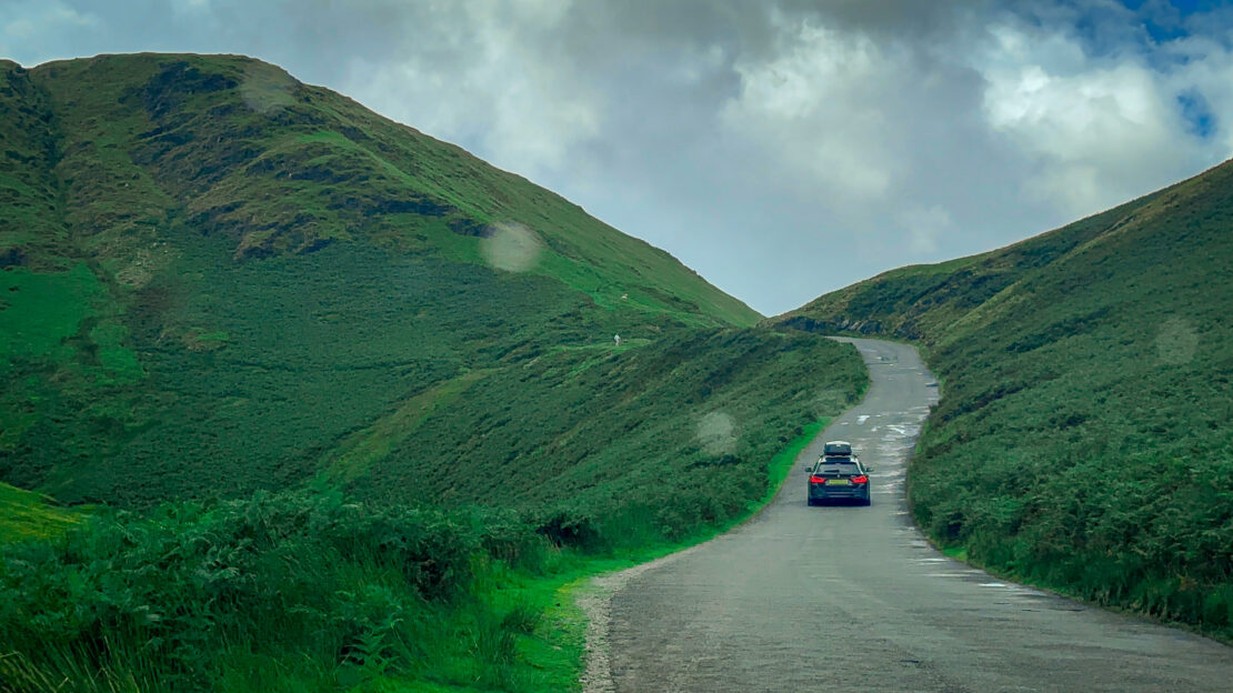 Car driving through the hills in the Lake District 