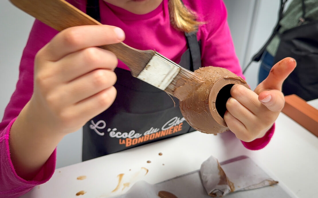 Child painting chocolate cauldron at Bonbonniere Geneva Switzerland