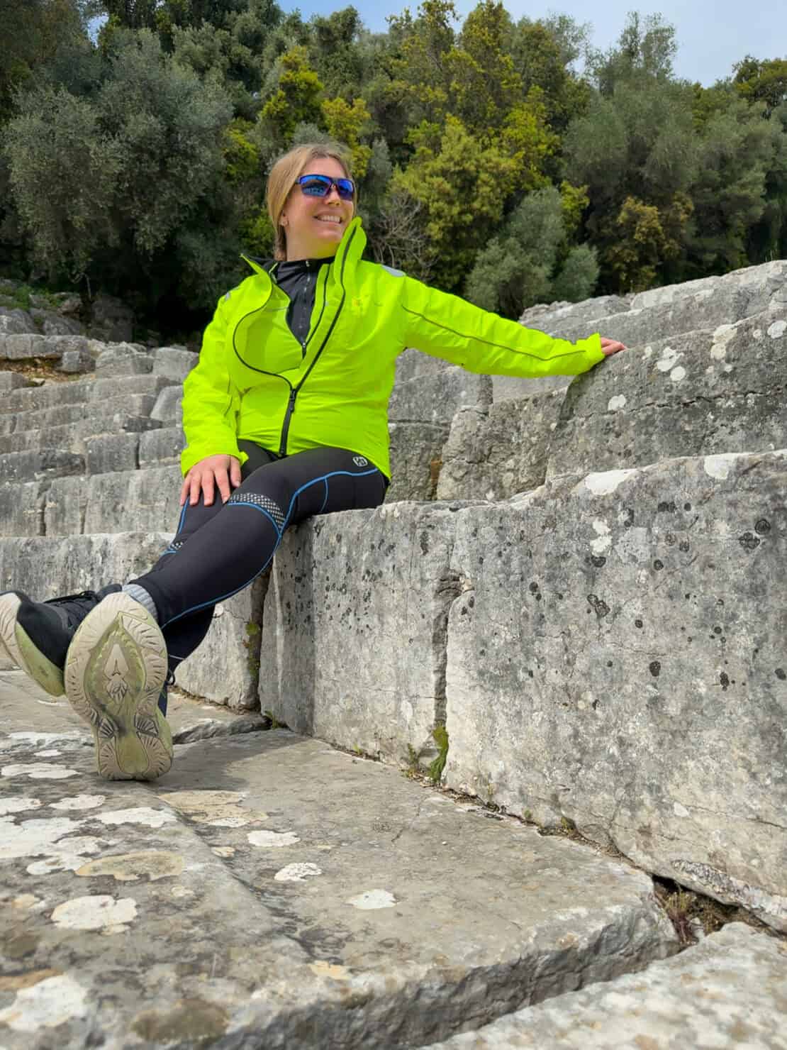 Abigail King sitting on a wall at Butrint in Albania - cycling in Albania