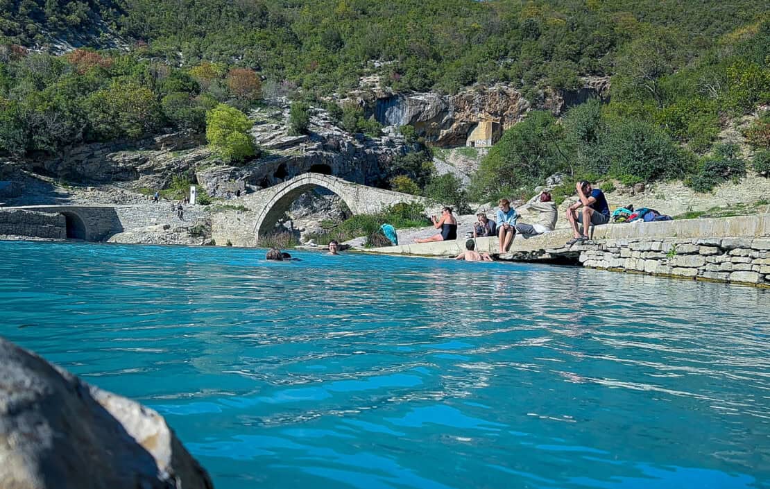 People sunbathing at the Benjë thermal springs in Albania - cycling in Albania