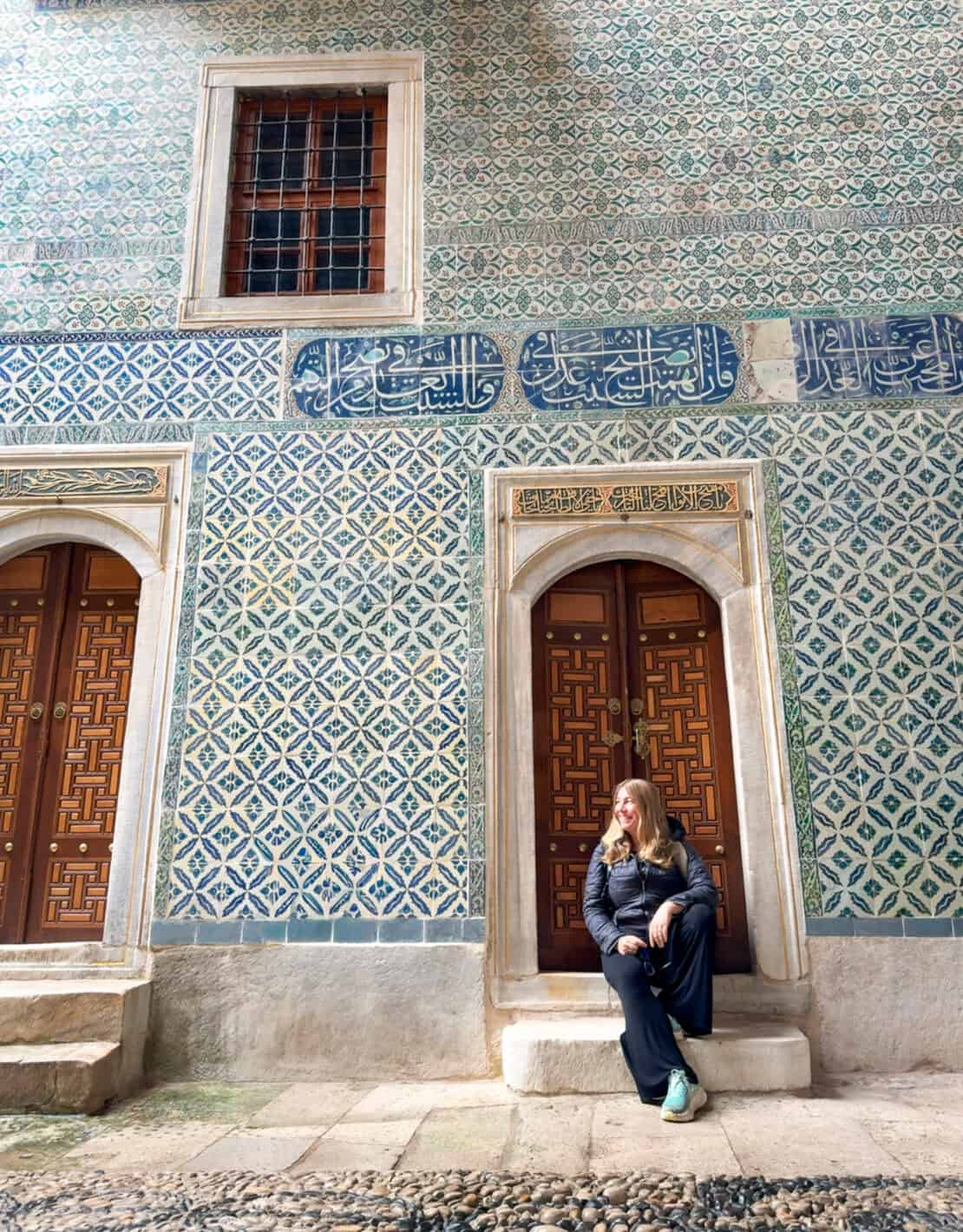 Abigail King sitting on steps surrounded by traditional Iznik tiles in Istanbul, Turkey - Turkish souvenirs