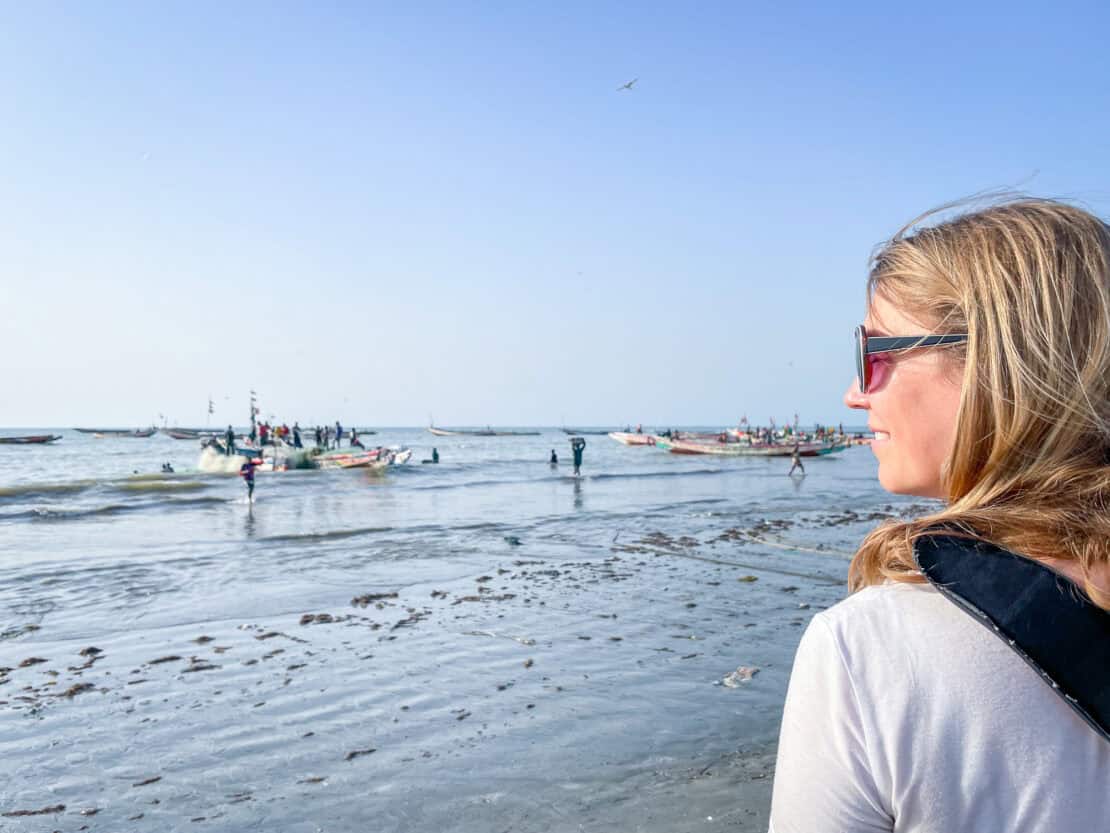 Abigail King looking out to see fishing boats return on Tanji Market in the Gambia