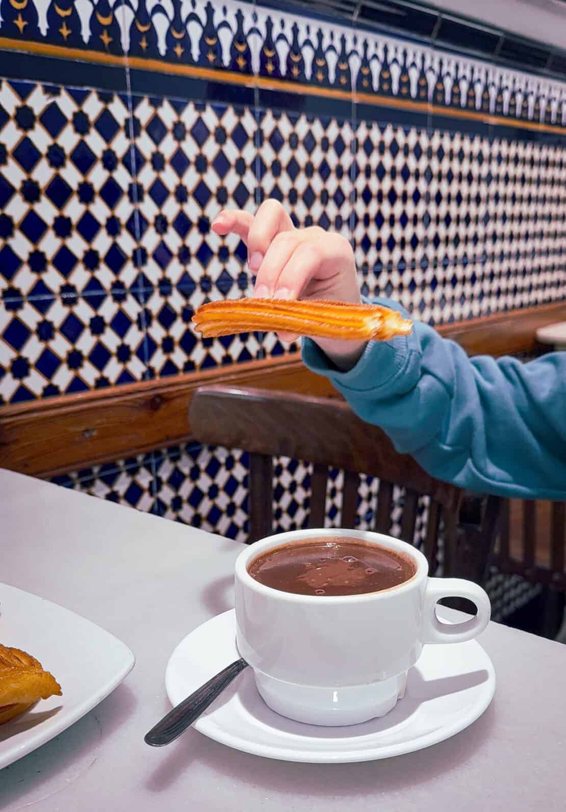 Churros and chocolate with background azulejos tiles in Valencia Spain
