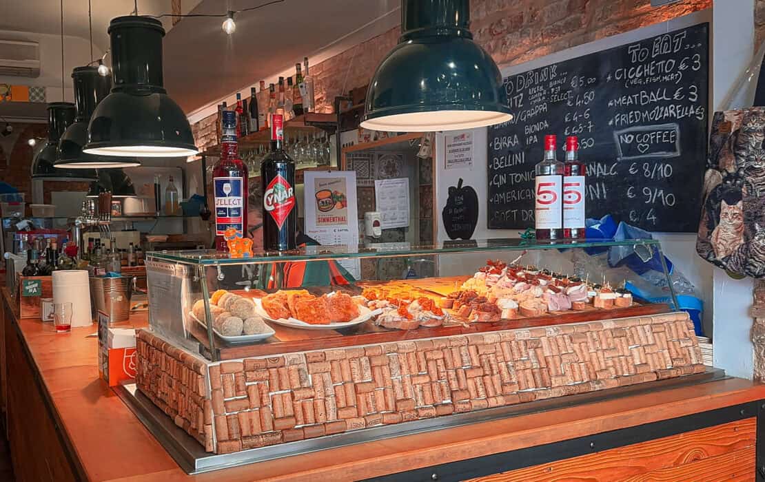 Traditional bacaro food counter displaying cicchetti and Venetian specialities in Venice, Italy