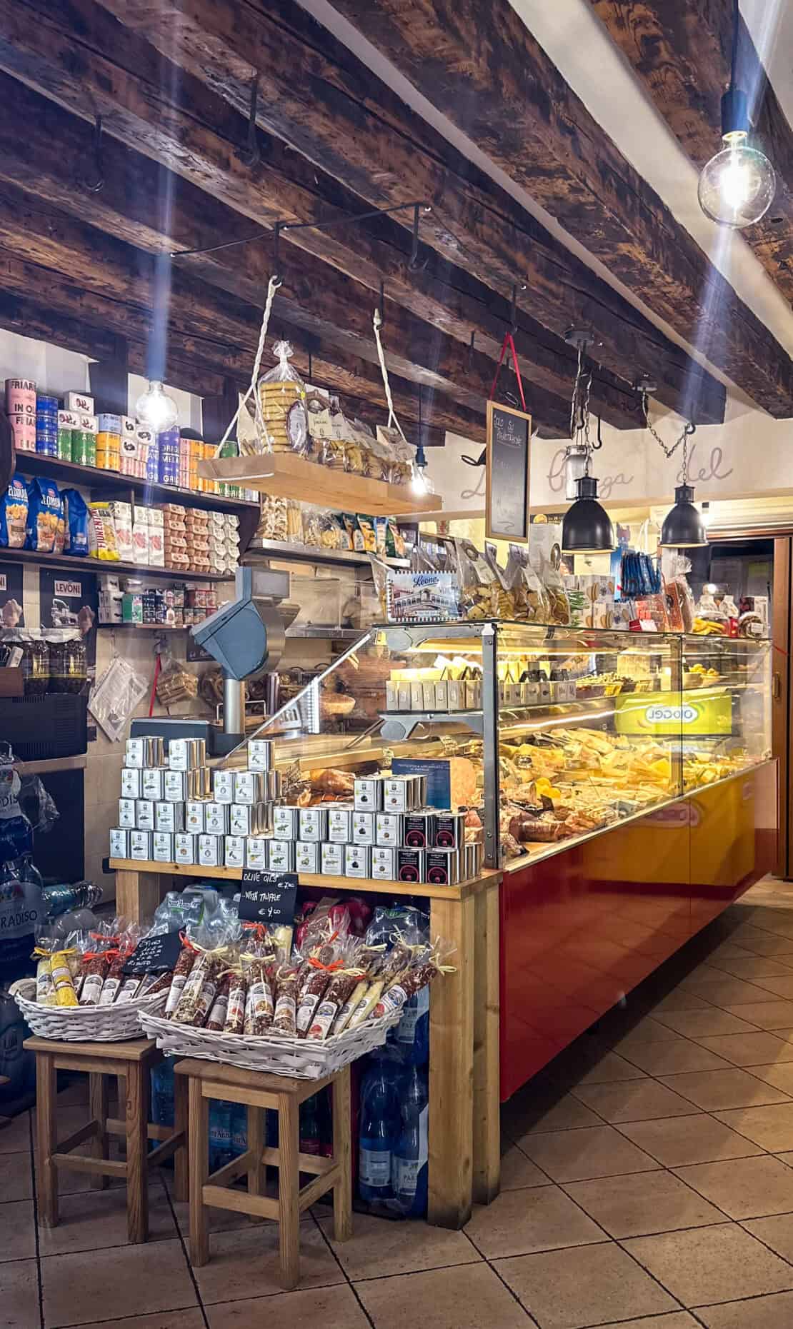 Traditional Venetian food shop displaying local cheeses, cured meats and regional delicacies in Venice, Italy