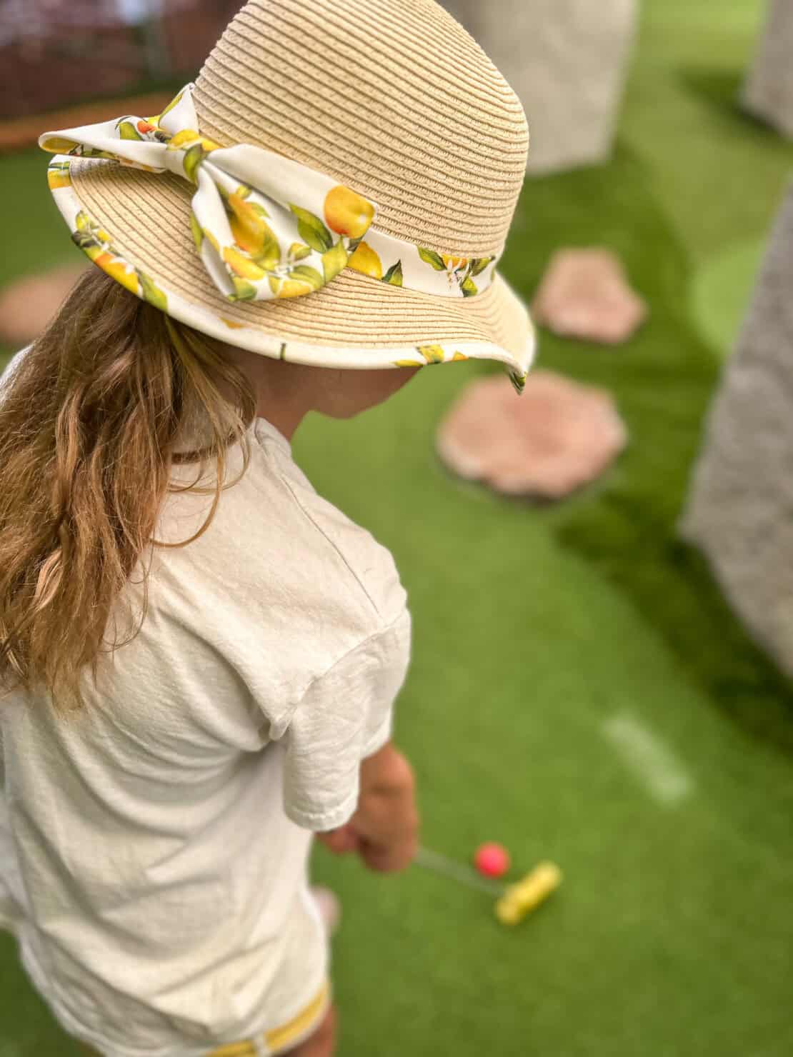 Child playing indoor mini golf on an Arthurian-themed course in Herefordshire