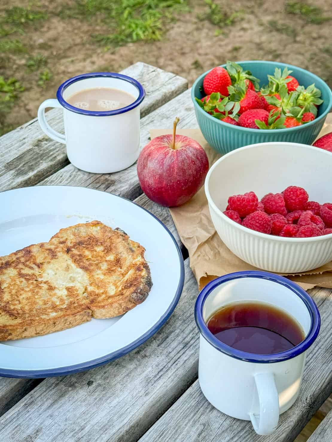 Glamping breakfast in Herefordshire with apple strawberries raspberry eggy bread and tea England