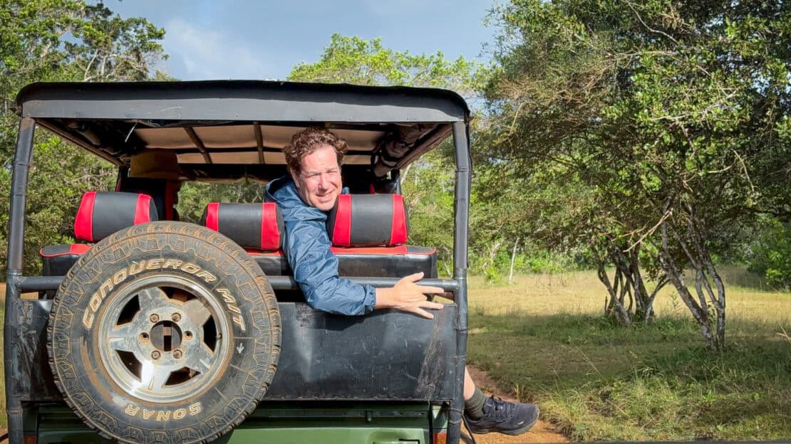 Man looking out the back of a safari jeep in Hurulu in Sri Lanka