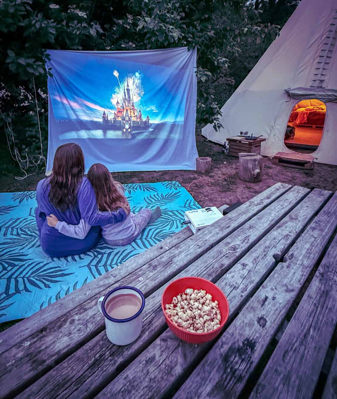 Mother and daughter watching an outdoor film screening at White House Glamping in Herefordshire
